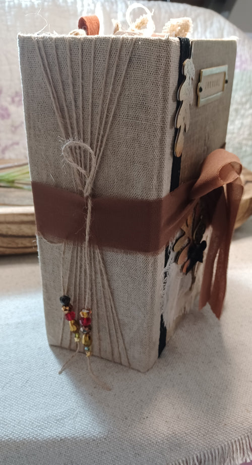 Thick handmade Autumn Remembered junk journal showing wrapped binding and layered pages