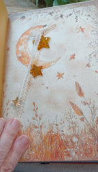 Gold mercury-glass-style resin star charm embellishment on a handmade autumn journal
