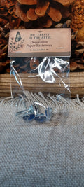Packaged assorted blue and white cabochon decorative paper fasteners with patterns that vary by set