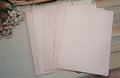 Fanned assortment of naturally avocado-dyed paper in dusty pink and pale rose tones