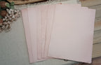 Fanned assortment of naturally avocado-dyed paper in dusty pink and pale rose tones