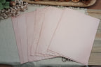 Assorted 8.5 by 11 inch avocado-dyed papers with natural variations in soft pink tones