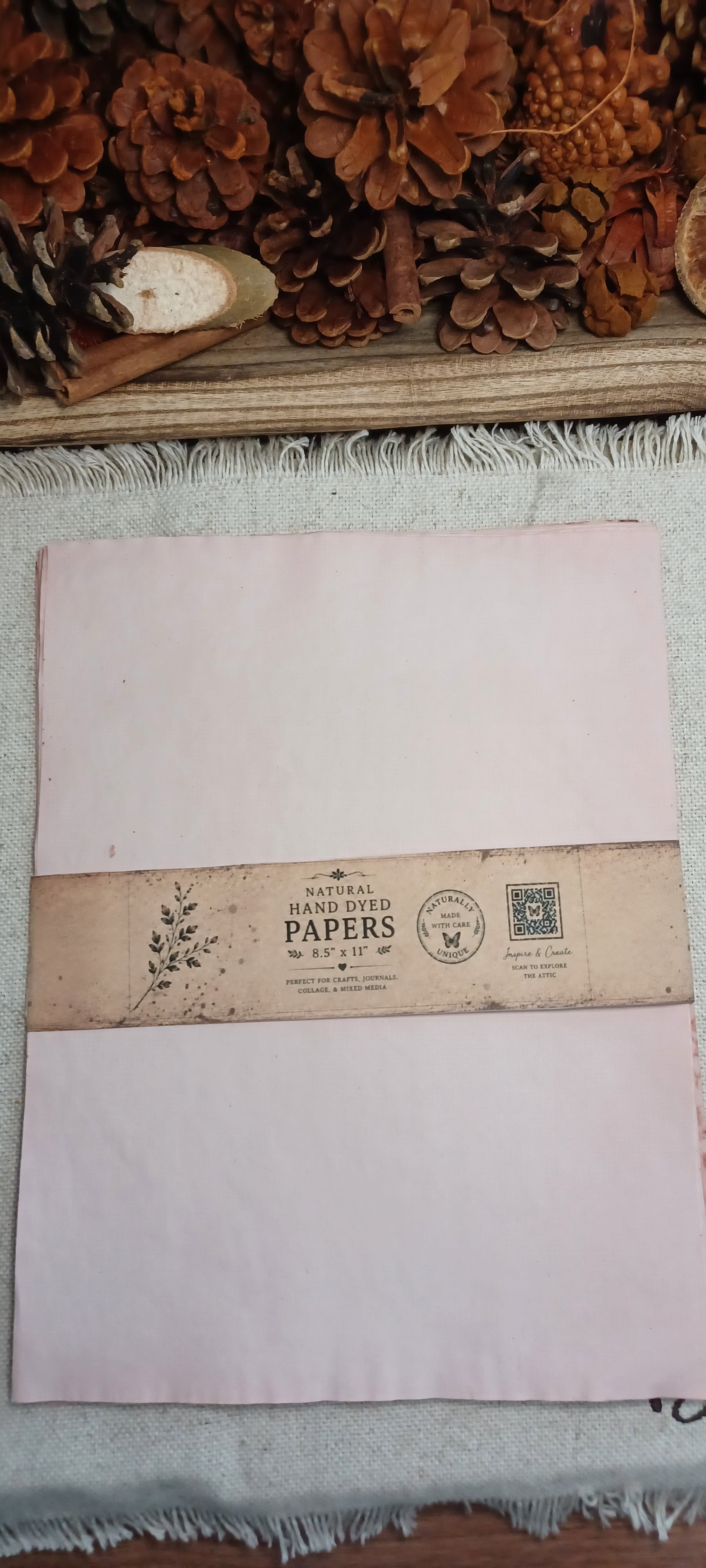 Pack of avocado-dyed paper in dusty pink tones wrapped with Butterfly in the Attic paper band