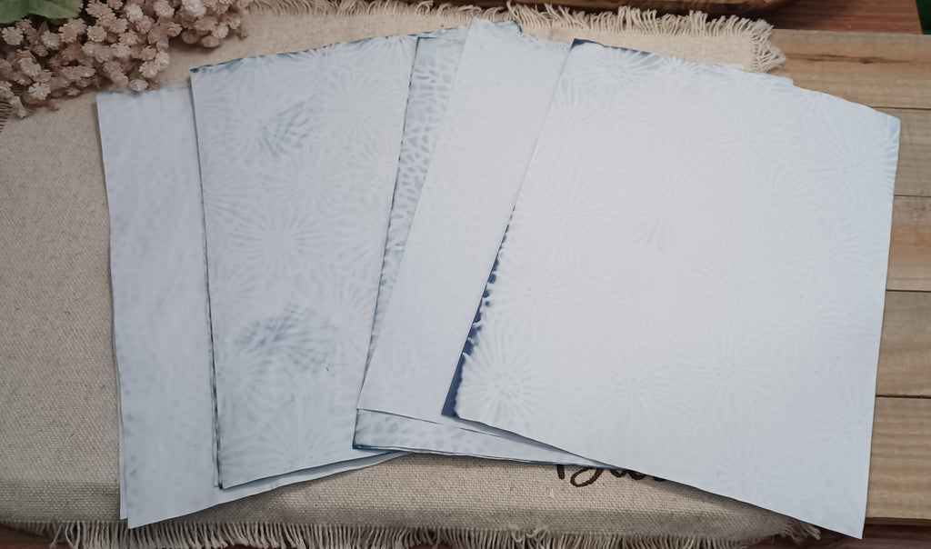Set of naturally red cabbage dyed 8.5 x 11 paper sheets fanned out to show soft sky blue and aqua blue color variations