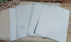 Fanned assortment of hand dyed red cabbage paper showing natural variations in blue tone and organic surface markings