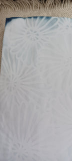 Close-up of sky blue red cabbage dyed paper featuring a decorative stencil pattern created during the hand dyeing process