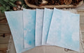 Five Light Blue bubble-blown 8.5 x 11 paper sheets fanned out to show varied handmade bubble patterns