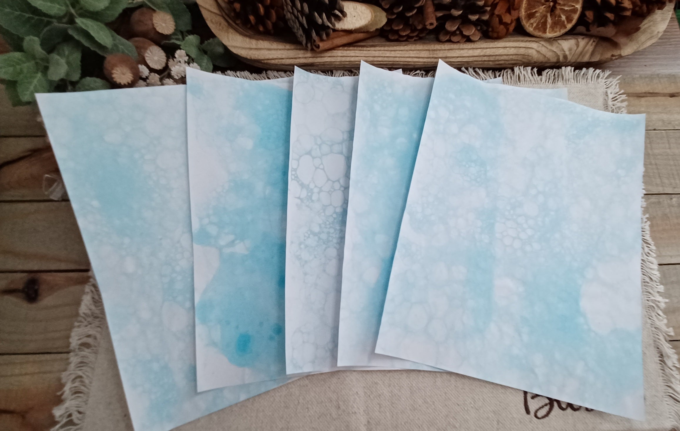 Five Light Blue bubble-blown 8.5 x 11 paper sheets fanned out to show varied handmade bubble patterns