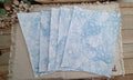 Five 8.5 x 11 Denim Blue bubble-blown paper sheets fanned out to show unique handmade bubble patterns