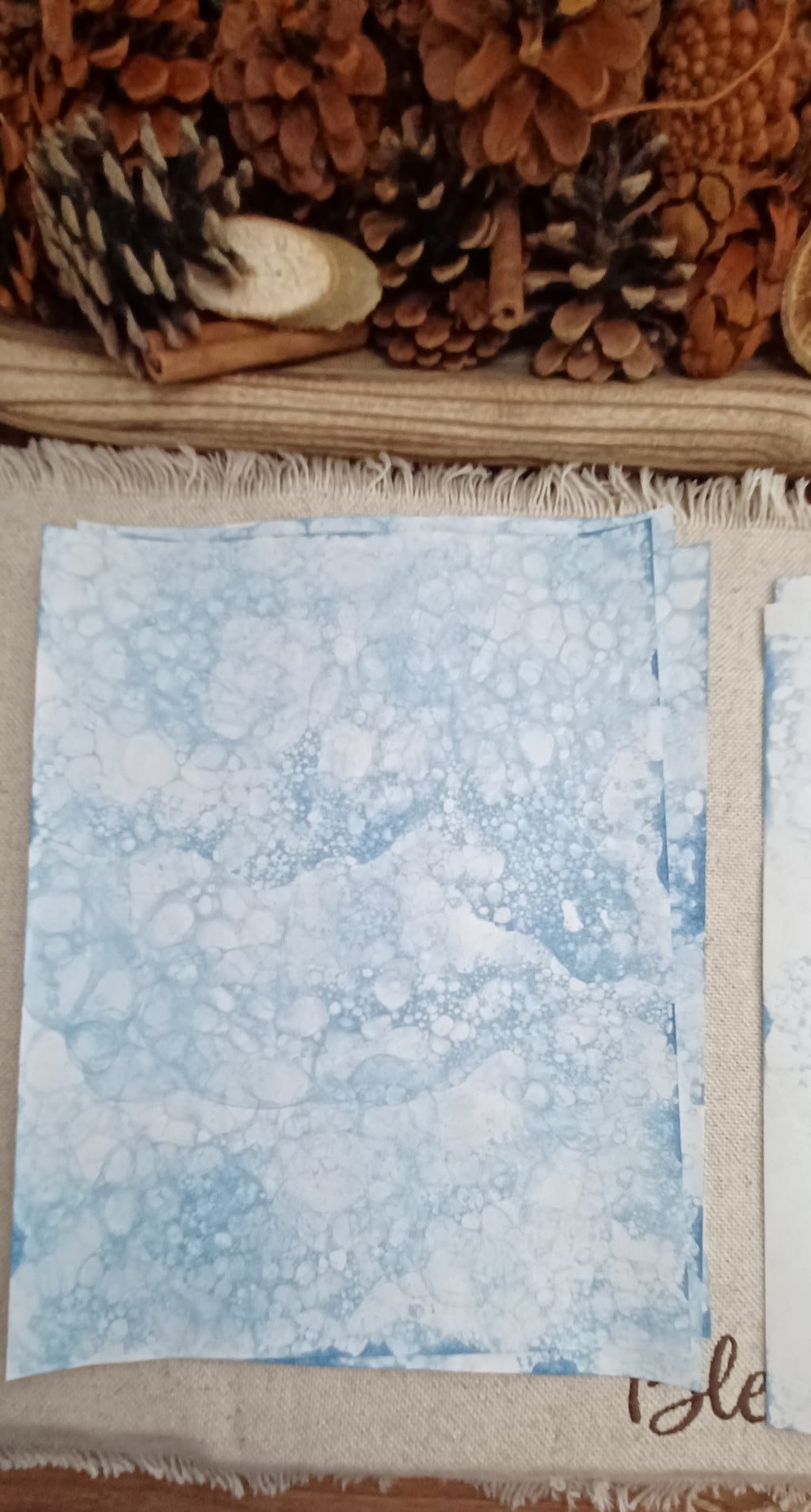 Hand-patterned blue paper featuring organic overlapping designs created by color-infused bubbles