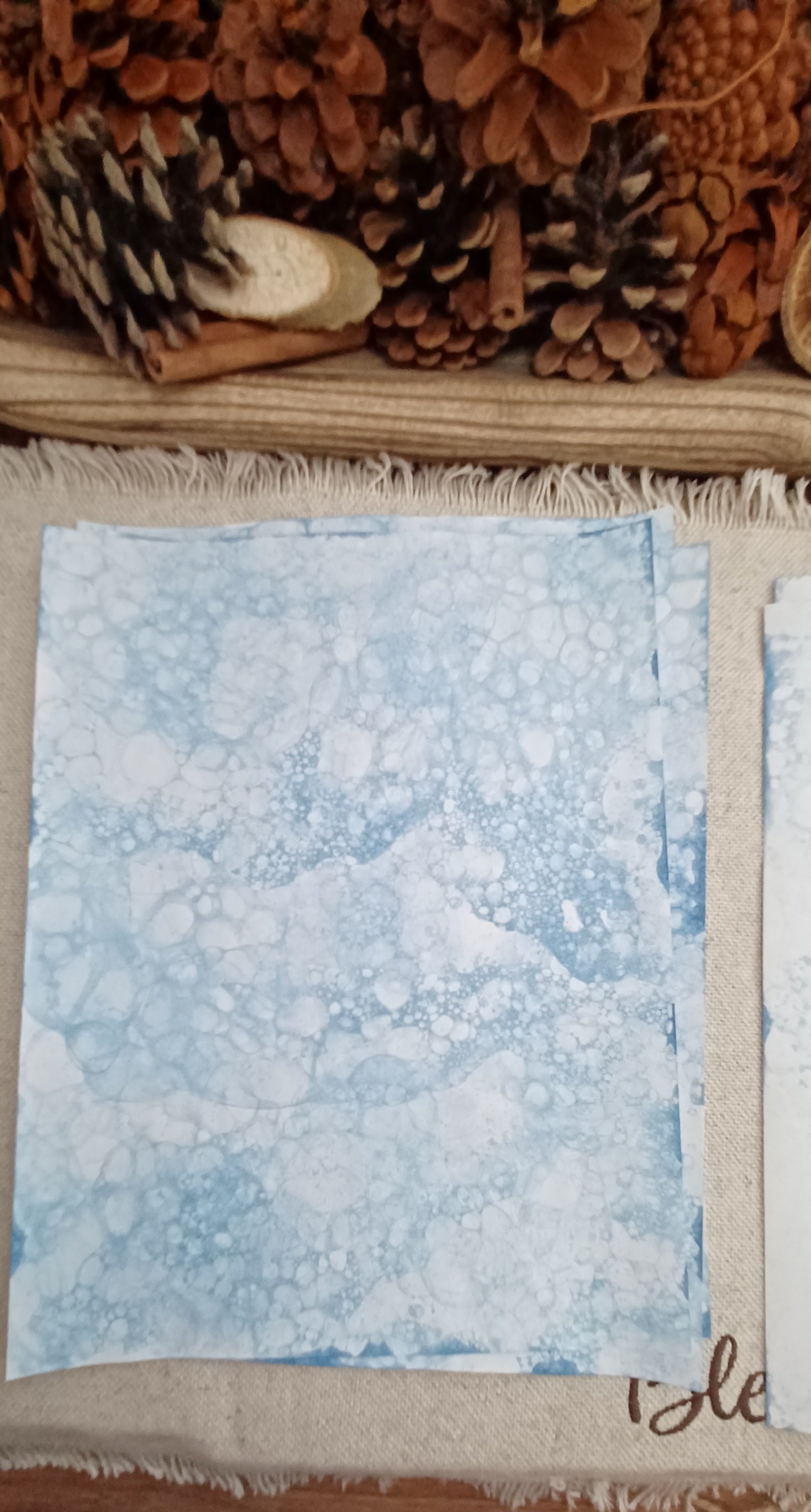 Hand-patterned blue paper featuring organic overlapping designs created by color-infused bubbles
