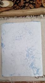 Back side of handmade Denim Blue bubble art paper with large and small overlapping circular bubble impressions