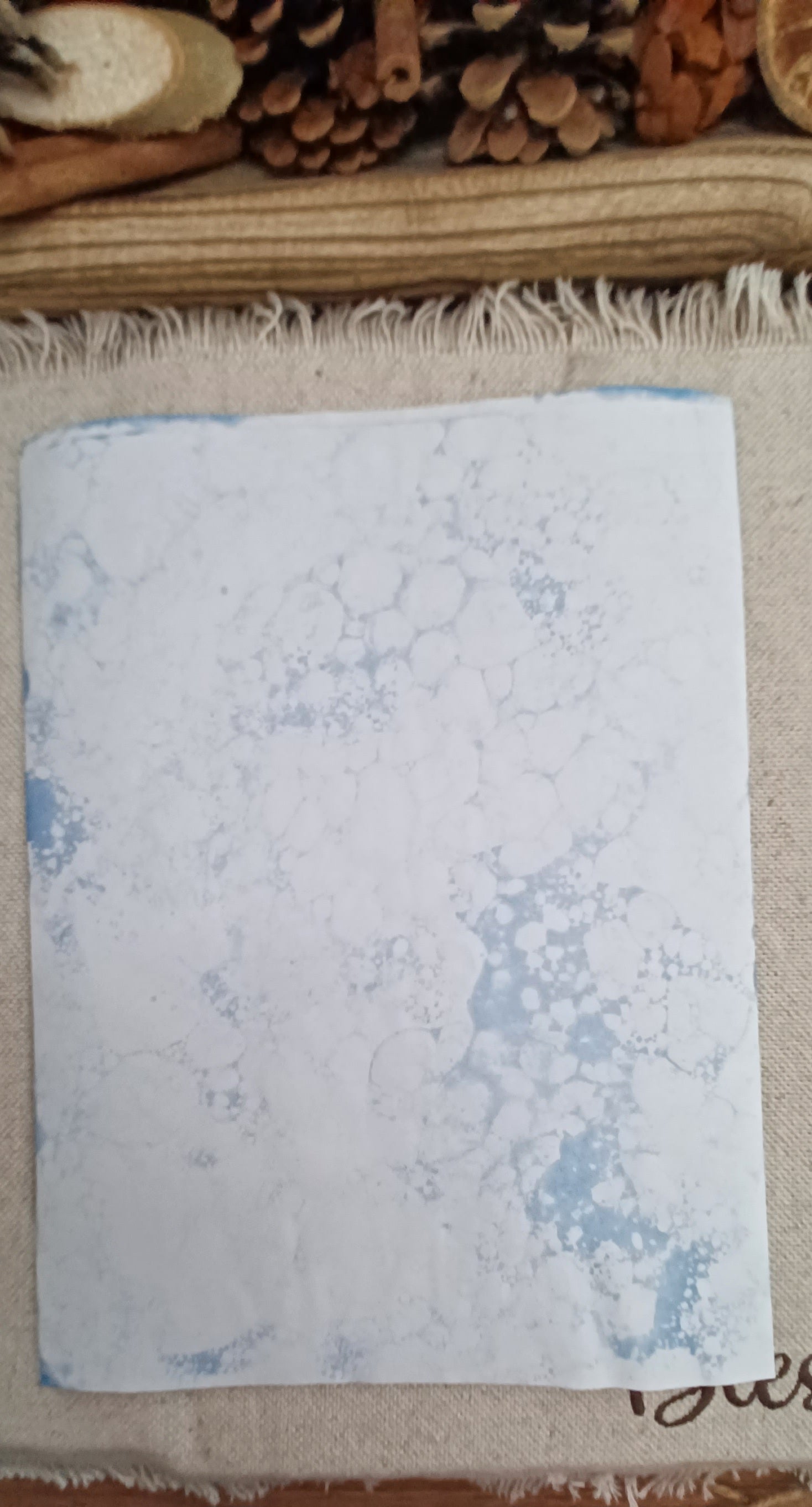 Back side of handmade Denim Blue bubble art paper with large and small overlapping circular bubble impressions