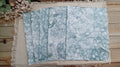 Five Green bubble-blown 8.5 x 11 paper sheets fanned out to show varied handmade bubble patterns