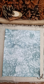Green hand-patterned paper with large bubble impressions surrounded by fine lacy networks of smaller bubbles