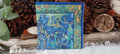 Blue iris floral cocktail napkin in cobalt, turquoise and green displayed with rustic botanical decor.