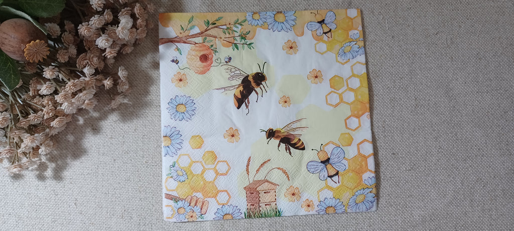 Bee and honeycomb luncheon paper napkin with beehive, blue daisies and yellow floral details for decoupage and paper crafts.