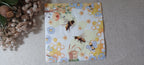 Bee and honeycomb luncheon paper napkin with beehive, blue daisies and yellow floral details for decoupage and paper crafts.