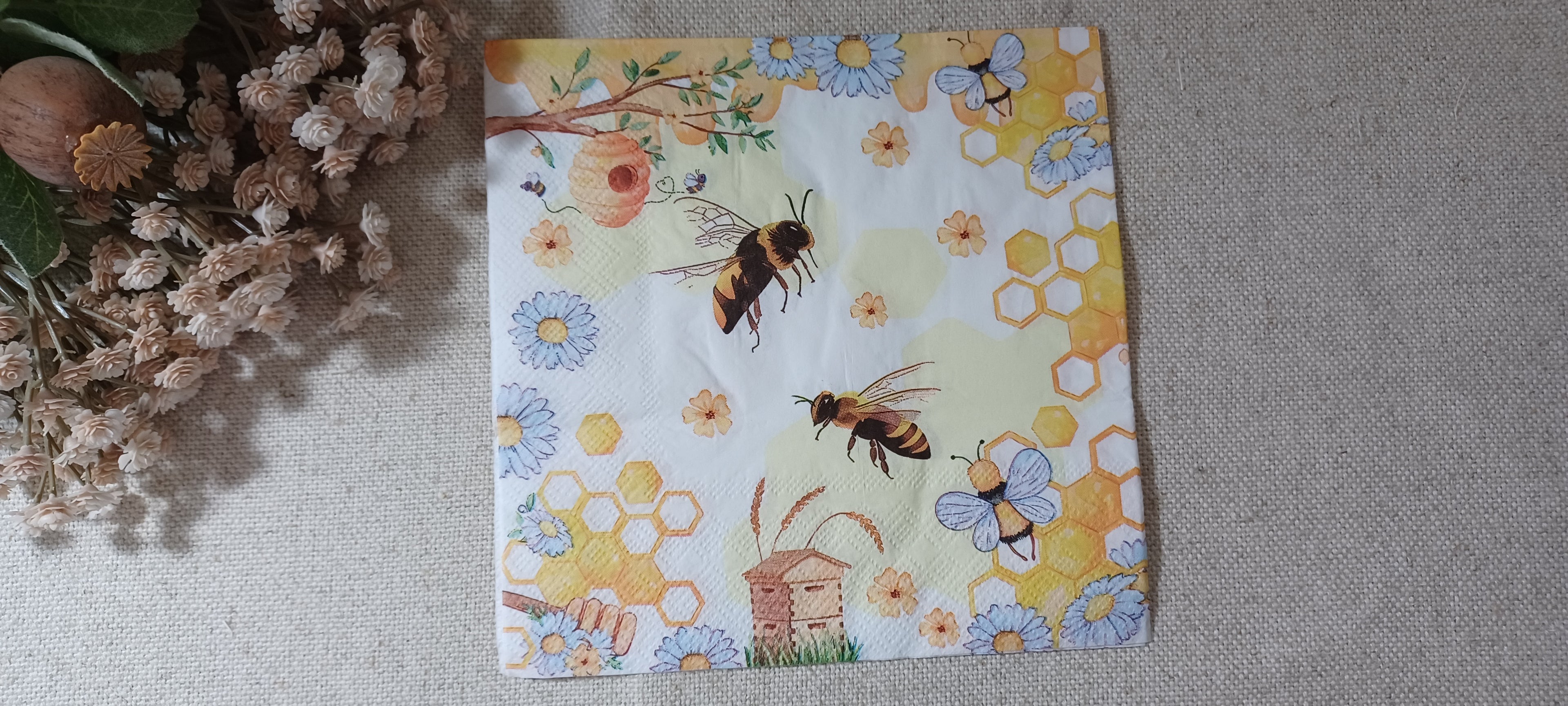 Bee and honeycomb luncheon paper napkin with beehive, blue daisies and yellow floral details for decoupage and paper crafts.