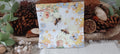 Bee and honeycomb luncheon paper napkin with beehive, blue daisies and yellow floral details for decoupage and paper crafts.