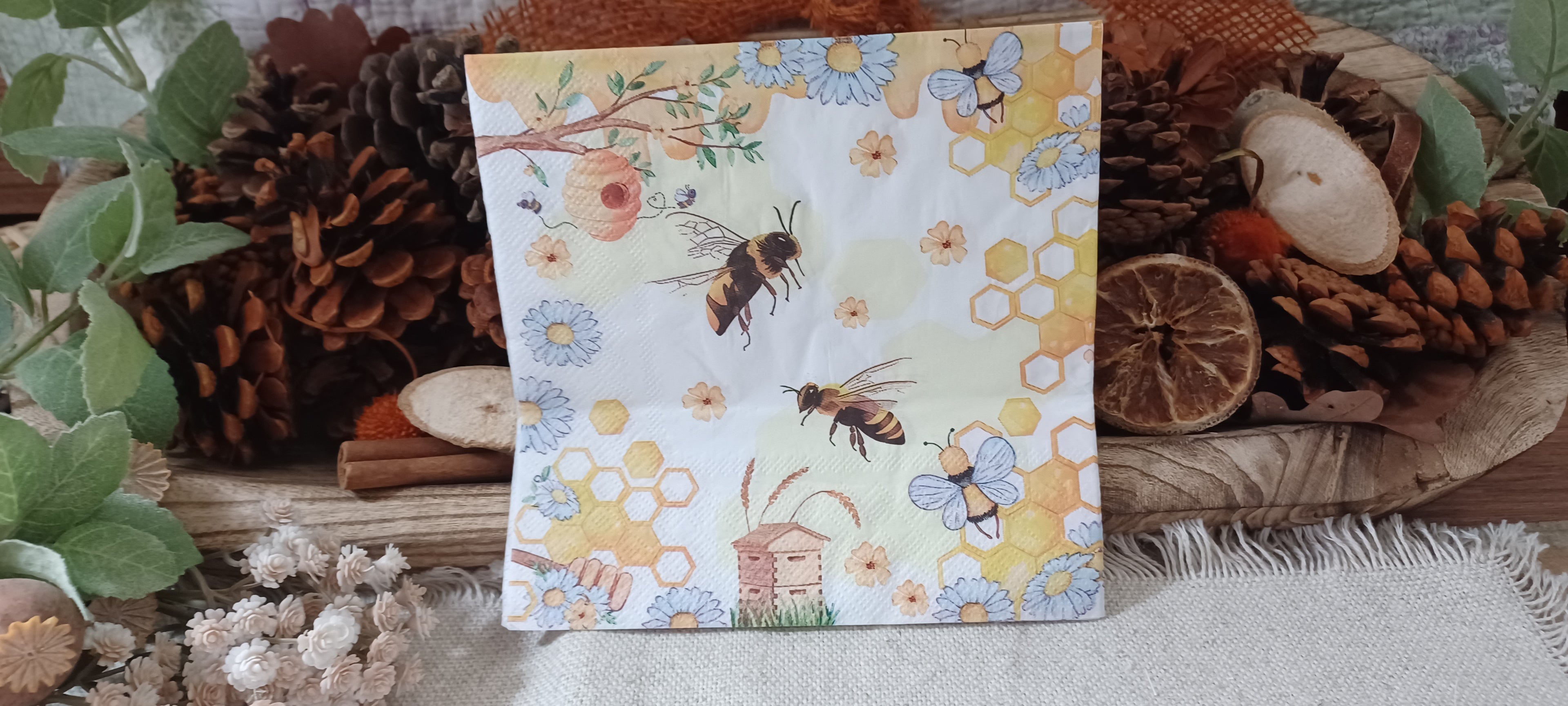 Bee and honeycomb luncheon paper napkin with beehive, blue daisies and yellow floral details for decoupage and paper crafts.