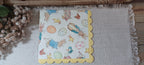 Luncheon-size Easter paper napkin featuring storybook rabbits, decorated eggs, chicks, ducks and a yellow scalloped border.