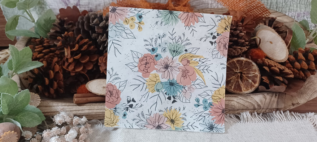 Luncheon-size decorative paper napkin showing alternate coral, teal and mustard floral bouquet pattern.