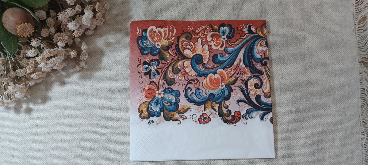 Decorative Rosepaint paper napkin featuring traditional Norwegian-style rosemaling flowers and scrolling blue and coral foliage.