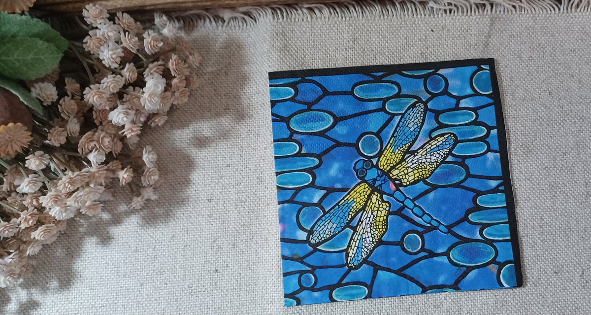 Blue mosaic stained glass pattern on decorative paper napkin in cobalt, turquoise, yellow and black.