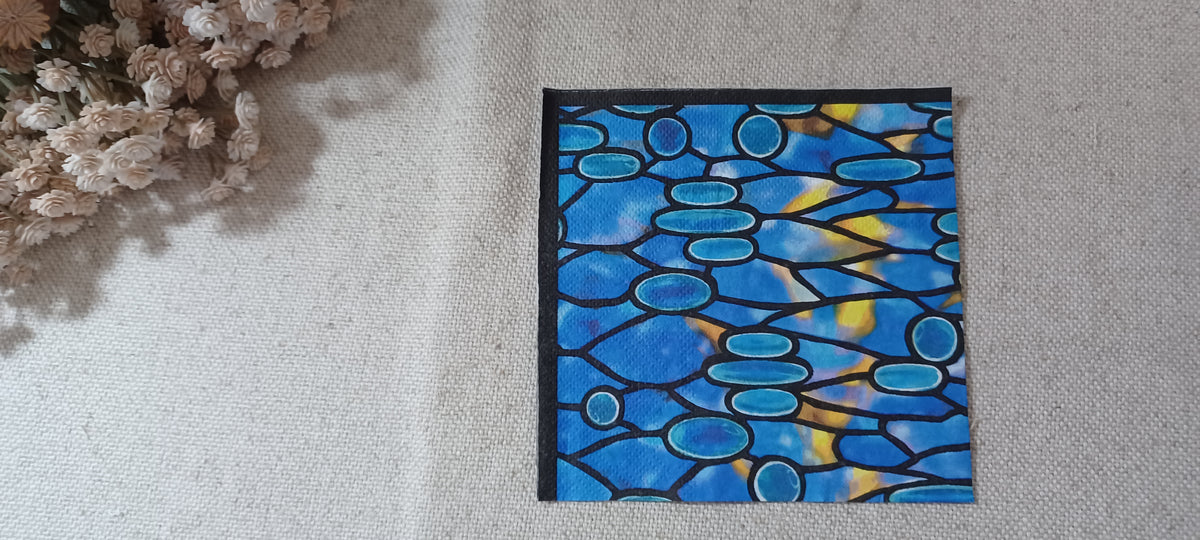Blue mosaic stained glass pattern on decorative paper napkin in cobalt, turquoise, yellow and black.