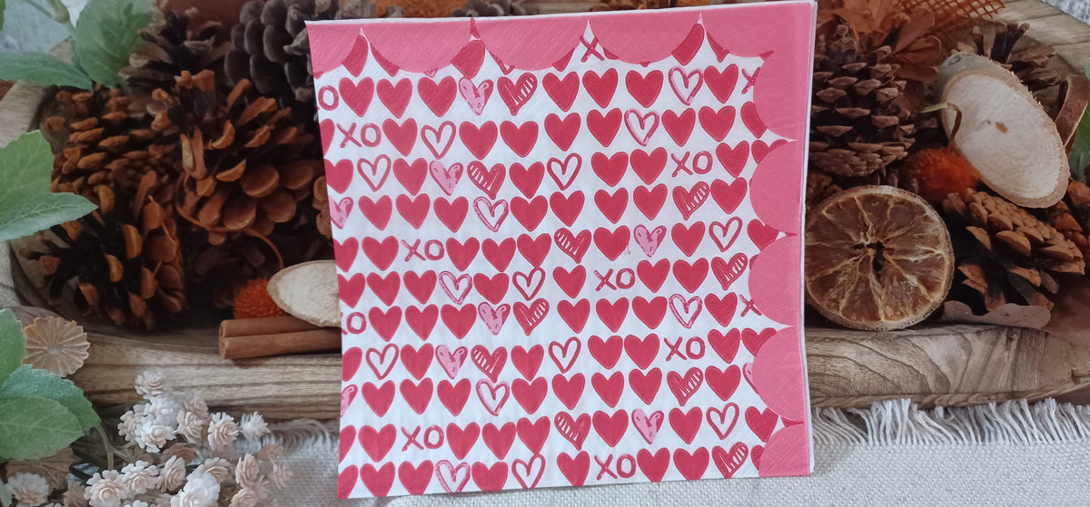 Red and pink hearts XO decoupage napkin displayed against a rustic botanical background.