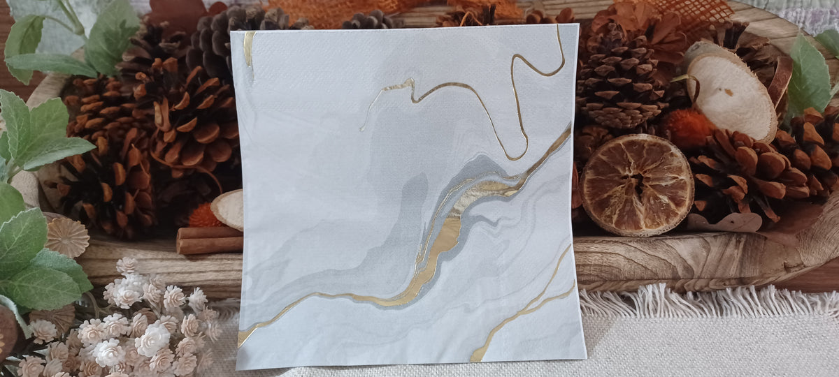 Close-up of reflective metallic gold foil detail on a white and gray marble luncheon napkin.