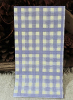 Lavender gingham paper guest napkin with a repeating purple and cream checkered pattern displayed with rustic styling