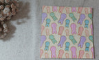 Reverse side of Easter paper napkin featuring an all-over pattern of pastel pink, lavender, aqua and peach bunny shapes.