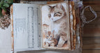Open cat junk journal spread surrounded by layered lace, fabric trims and ruffled page edges.