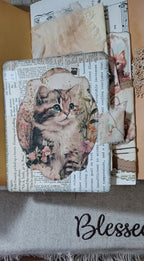 Layered vintage cat embellishment inside handmade lace and ruffle junk journal.