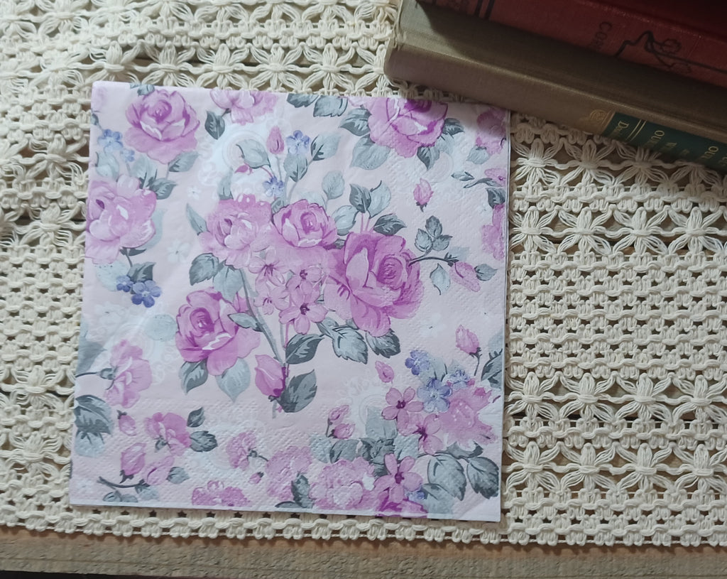 Full luncheon decoupage napkin with mauve roses, dusty blue flowers, and gray-green leaves in a vintage chintz pattern.