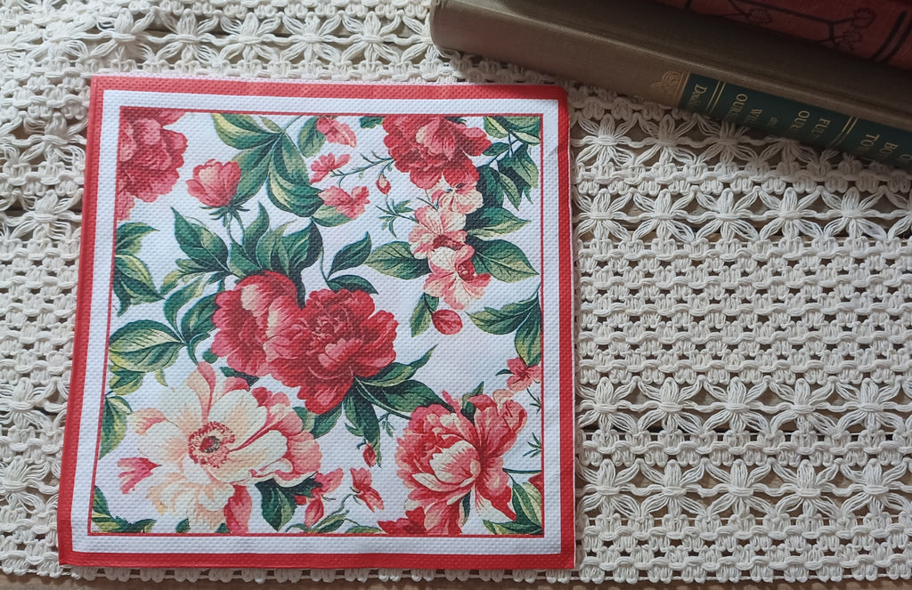 Full luncheon decoupage napkin with scarlet and coral flowers, green leaves, and a decorative red border.