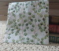 Watercolor eucalyptus leaf luncheon napkin with soft green foliage and slender brown stems on white.
