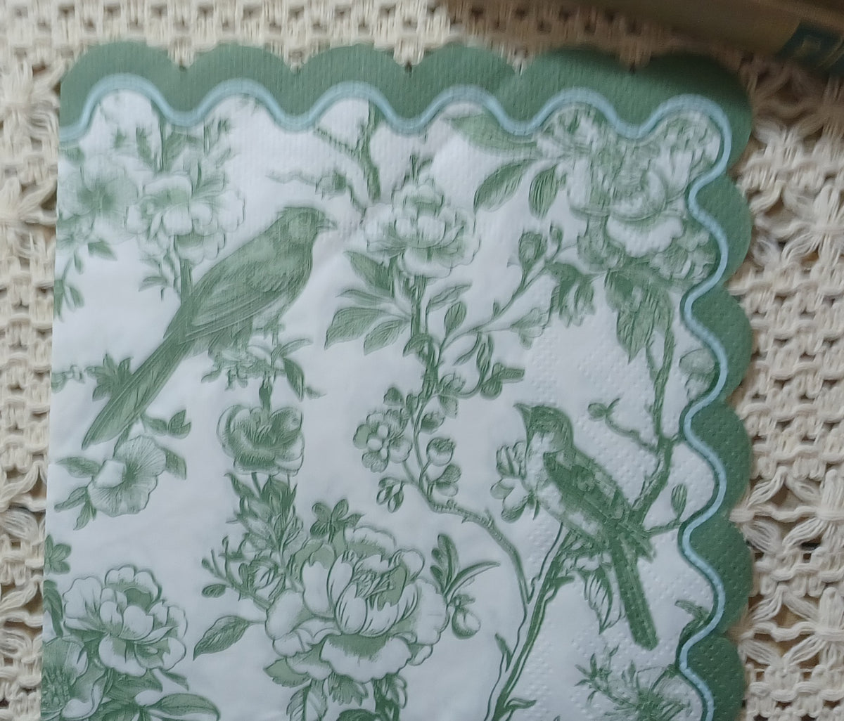 Full sage garden toile luncheon napkin featuring two birds, flowers, leafy branches, and a decorative scalloped edge.