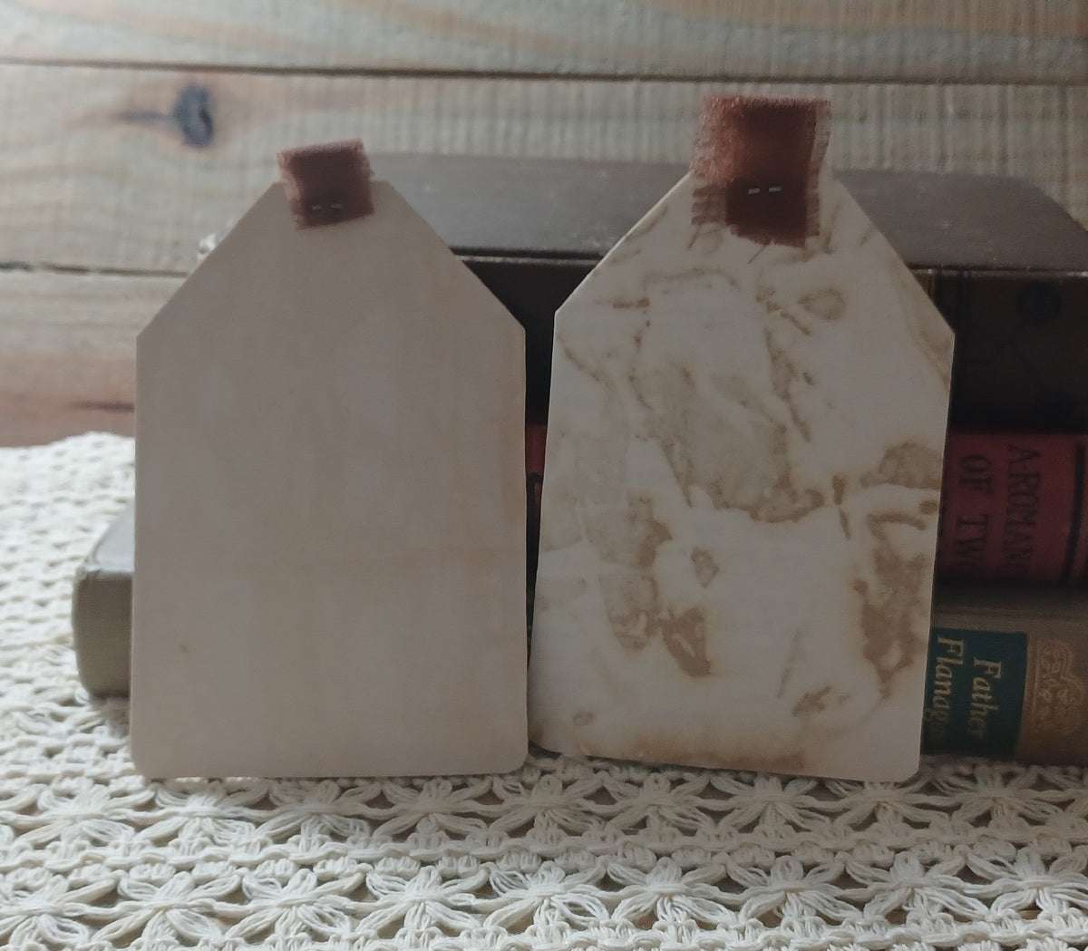 Close view of handmade grungy owl tags with mottled sepia texture and exposed vintage book text