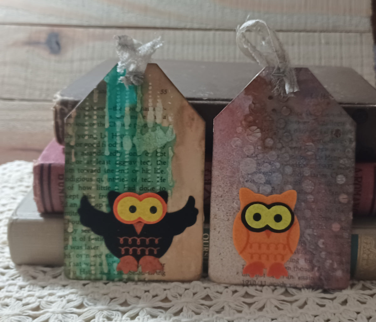 Black and orange owl tags layered over vintage text with turquoise green and smoky mauve mixed-media surfaces