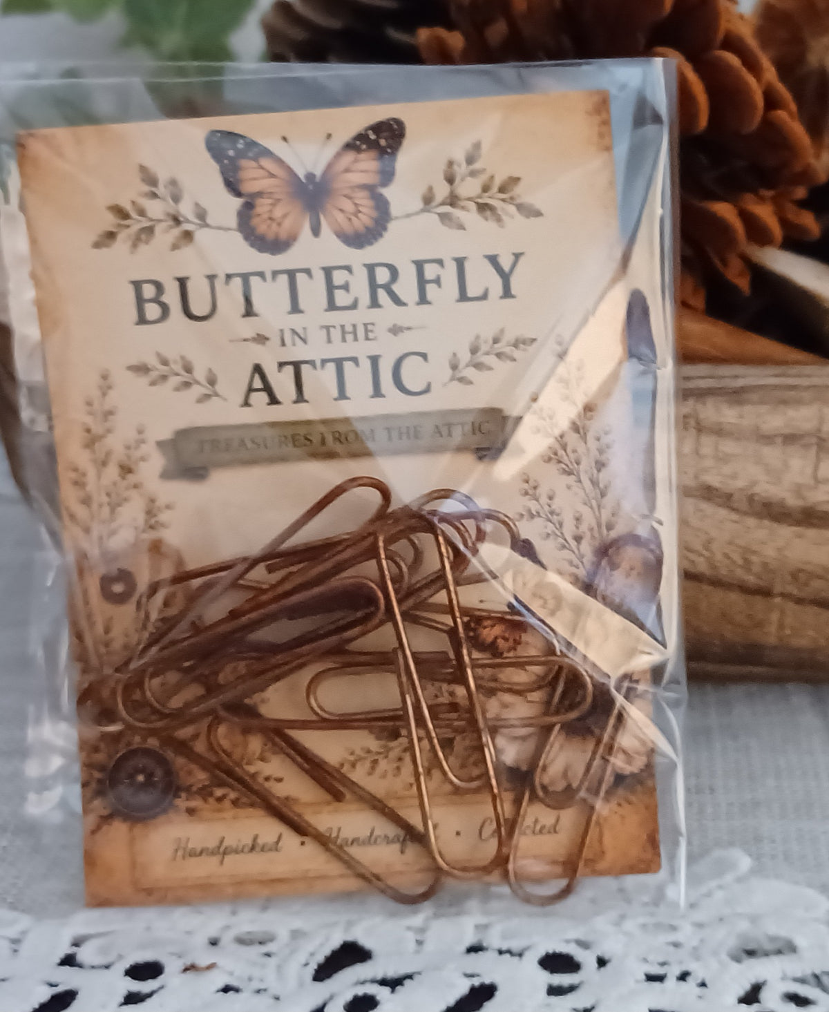 Oversized 2-inch coppery-brown paper clips packaged in a clear sleeve with a vintage-inspired Butterfly In The Attic backing card.