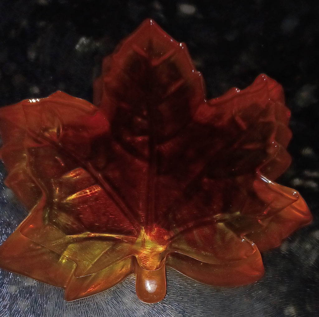 back side of handmade translucent resin maple leaf trinket dish in orange, red and golden autumn colors