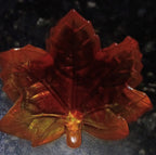 back side of handmade translucent resin maple leaf trinket dish in orange, red and golden autumn colors