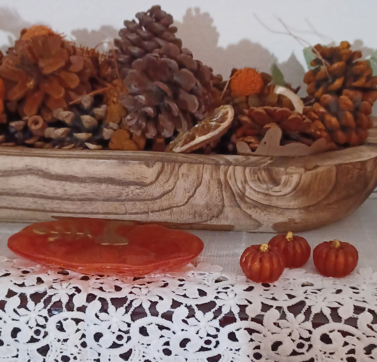 Side view of handmade orange pumpkin-shaped resin dish with three small coordinating pumpkins featuring gold stems.