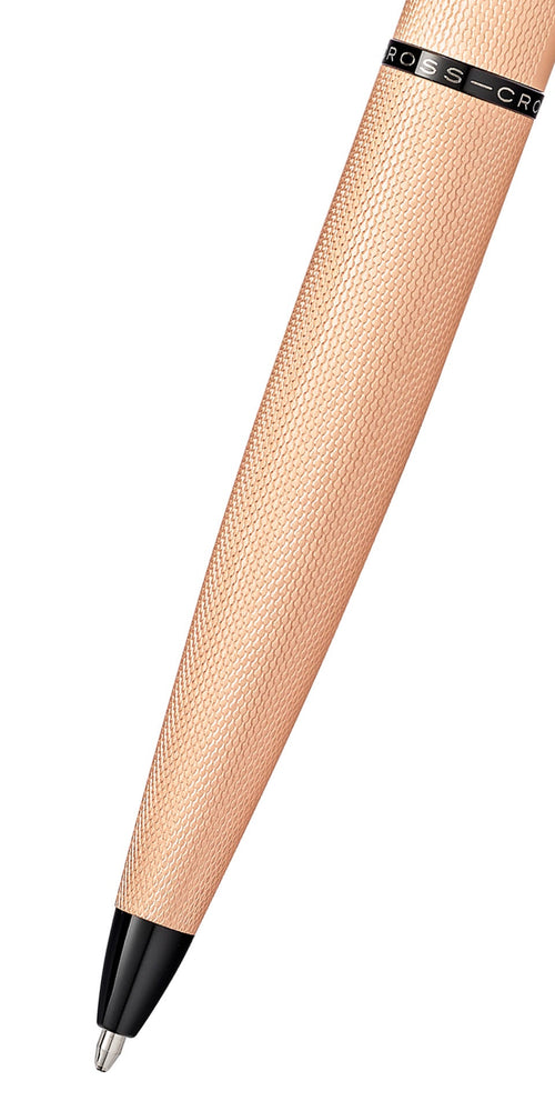 Close-up of Cross ATX brushed rose gold ballpoint pen showing textured barrel and black tip