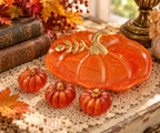 Four-piece handmade resin pumpkin decoration set displayed on a vintage table with lace, antique books, and autumn foliage.