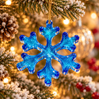 Handmade sparkling blue resin snowflake Christmas ornament displayed on a festive Christmas tree with gold hanging cord.