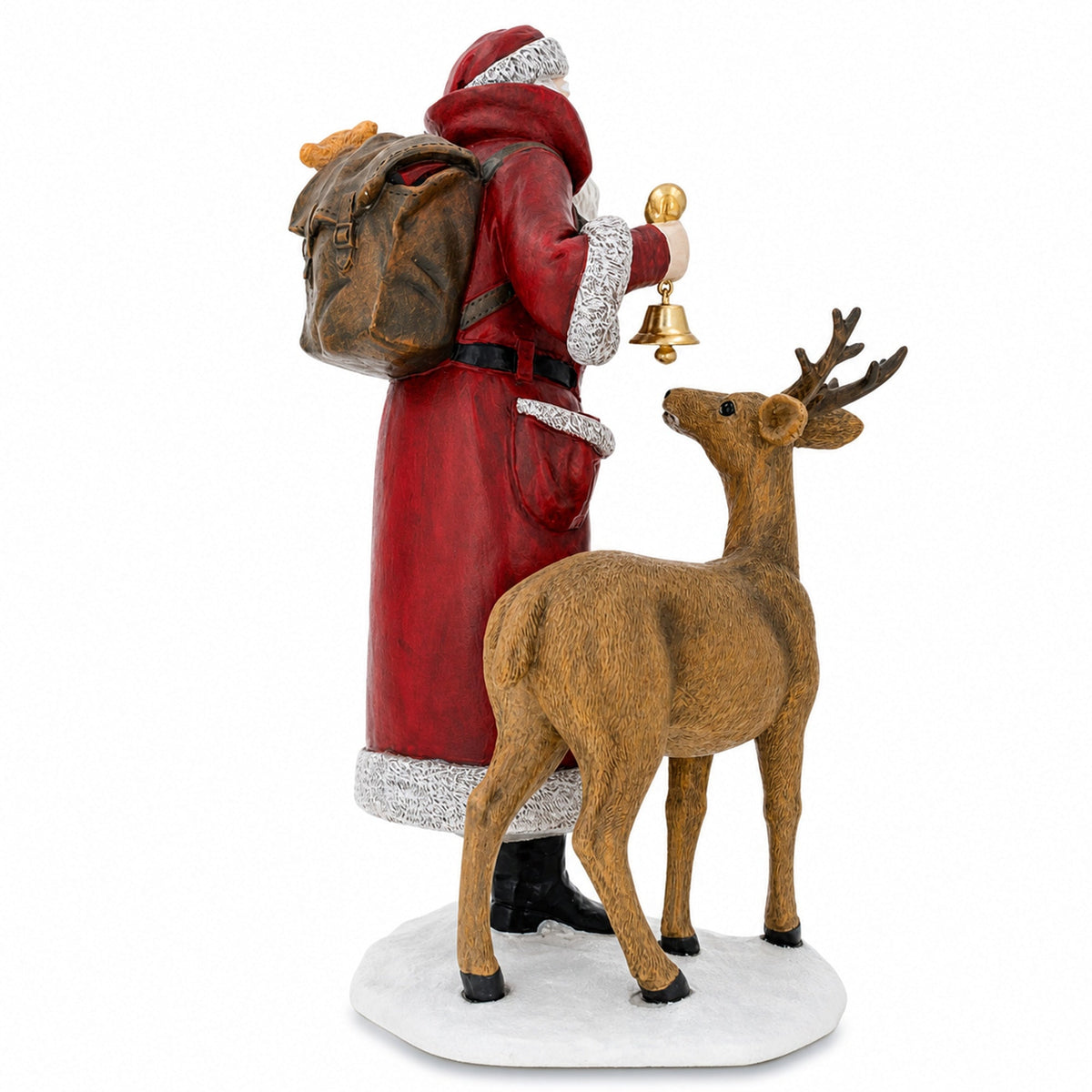 A Santa Claus figurine wearing a red coat with white trim, carrying a brown backpack and holding a gold bell, standing beside a brown deer on a white base against a white background.